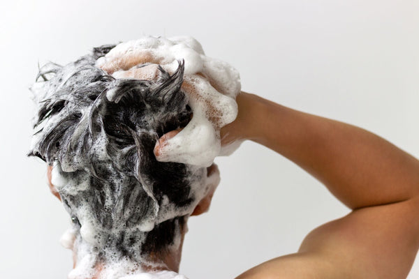 man shampooing hair using urth's purple shampoo