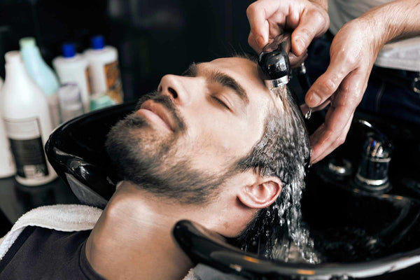 barber rinsing hair conditioner from man's hair, urth