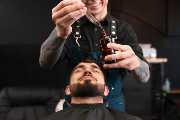 Barber using beard oil on client, urth