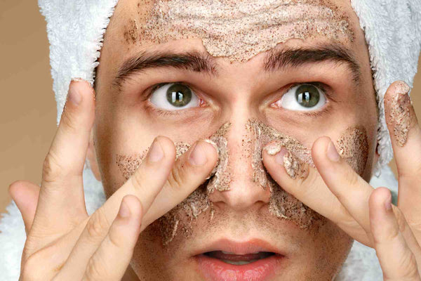 Man exfoliating with face scrub for oily skin, removing dead skin cells to reduce breakouts and improve skin texture, urth