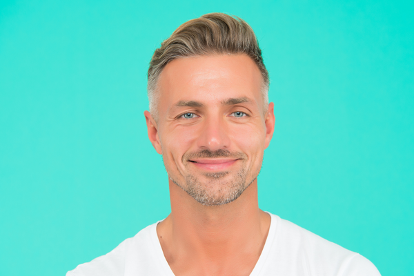 Groomed and Confident: Man Smiling in White T-Shirt with Great Hair and Skin