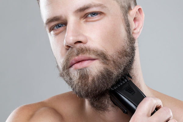 man trimming beard with electric trimmer to prevent ingrown hairs, URTH